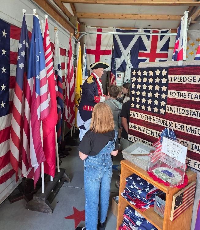 The Patriotic Bus decorated with historical flags and decor, filled with visiting students.